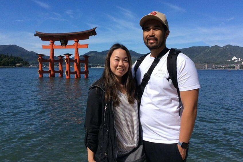 Una persona de pie en el agua, con un torii japonés tradicional al fondo. 3