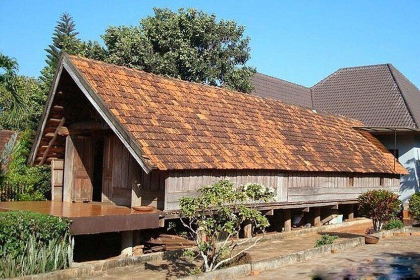 A wooden house with a sloped roof and a porch. 1