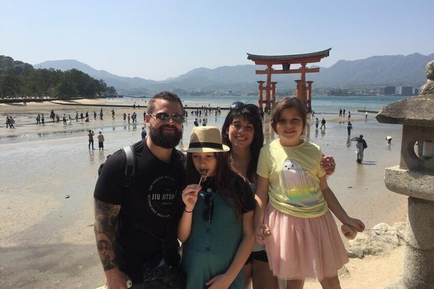 A family at a beach with a torii gate in the background. 1
