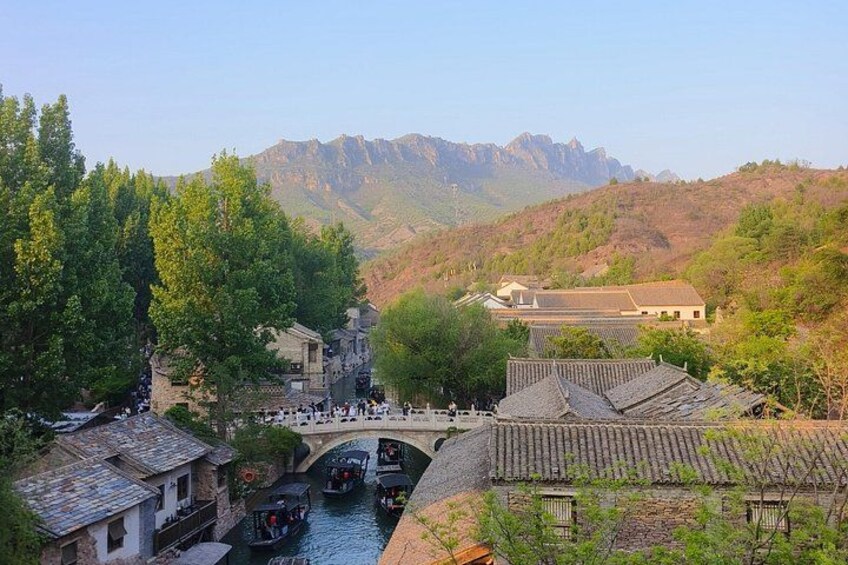 Un pont traditionnel enjambant une rivière, entouré d’arbres et de bâtiments à l’architecture traditionnelle. 4