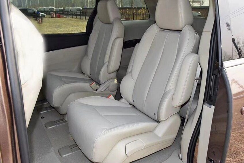 A vehicle interior with beige leather seats and a sunroof. 4