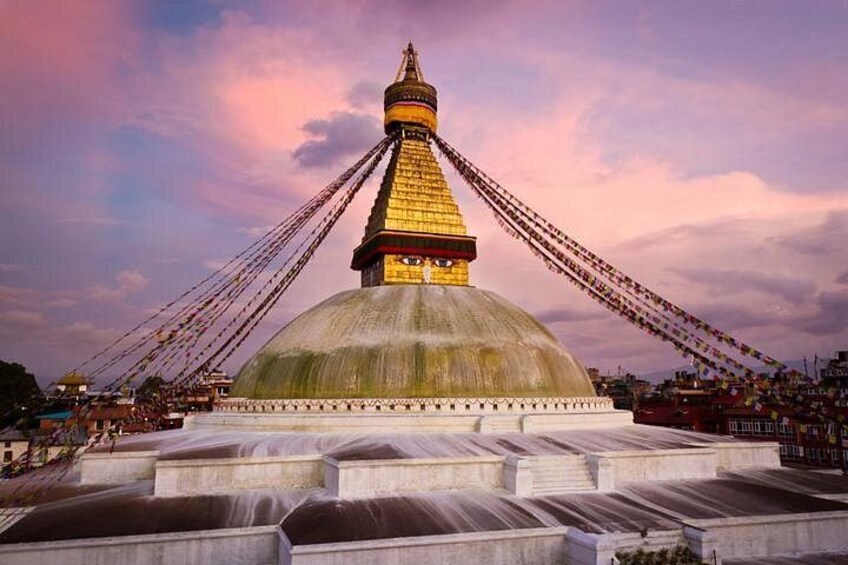 A large stupa with a golden spire, surrounded by a crowd of people. 1