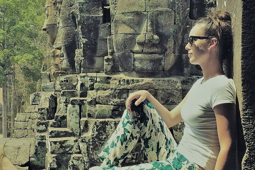 Happy client at Bayon temple with smiling buddha faces in background 1