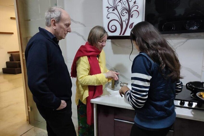 Tres personas en una cocina, una sosteniendo un recipiente. 5