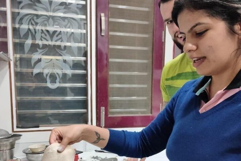 Una persona preparando comida, con una ventana y una puerta al fondo. 4