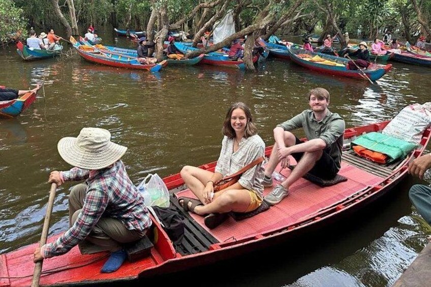 Mensen op een rode boot in een rivier, omringd door bomen. 3