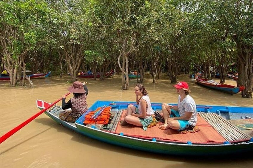 Een rivierzicht met een boot waarin drie personen zitten. 2