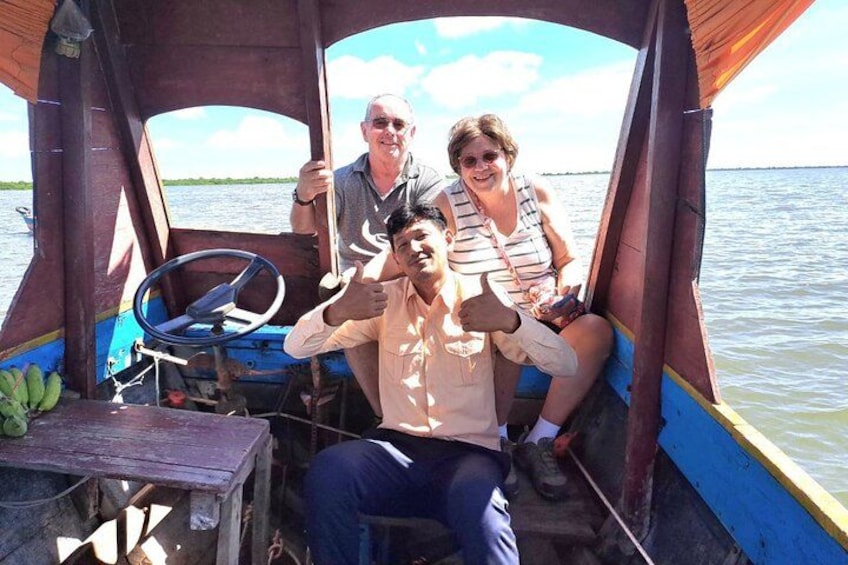 A wooden boat with a steering wheel, a table with bananas, and a person giving a thumbs-up. 3