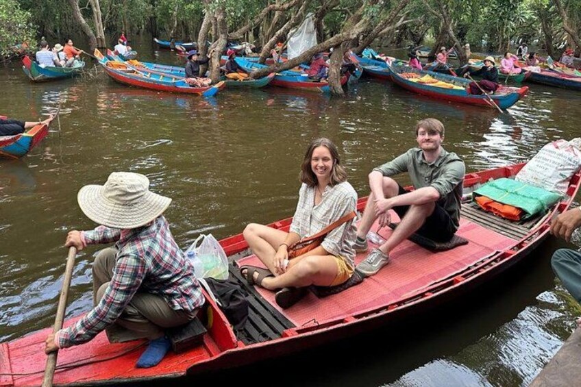 People on a red boat in a river surrounded by trees. 2