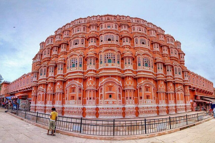 A large, ornate building with intricate architectural details and a surrounding fence. 2