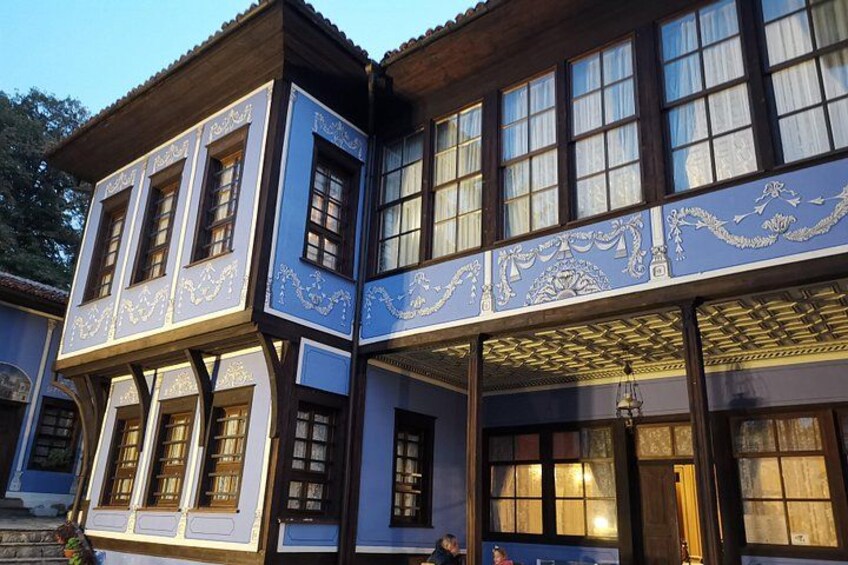 A two-story building with ornate blue and white trim, large windows, and a covered porch. 4