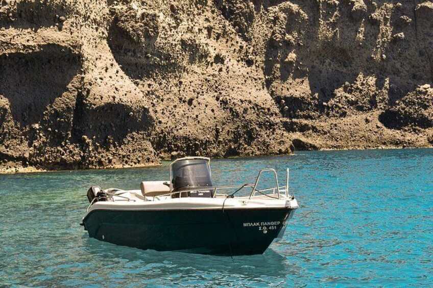 A boat named 'Myrna Ranger' on clear turquoise water with rocky cliffs in the background. 4