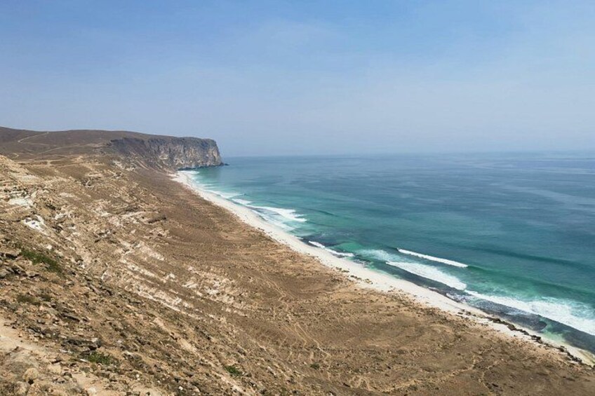 Un paisaje costero con una playa rocosa, olas del océano y un acantilado. 5