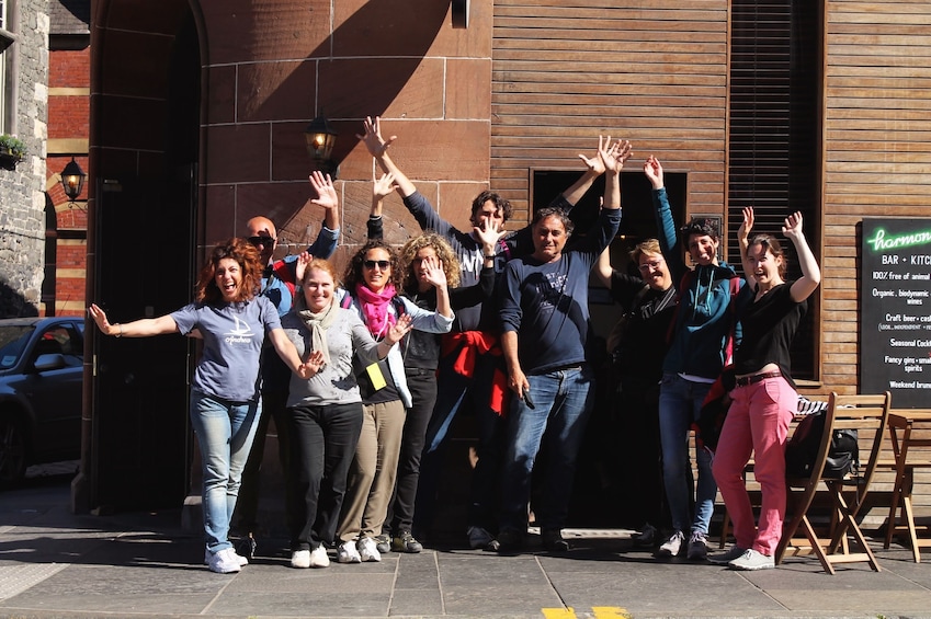 A group of people standing outside a building with raised hands. 3