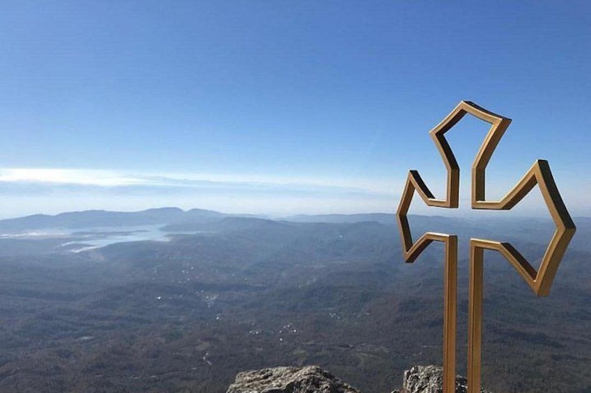 A cross-shaped landmark with a mountainous landscape in the background. 1