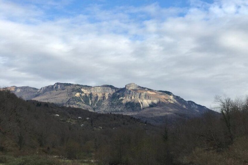 A mountain range with a prominent peak and a forested valley. 5