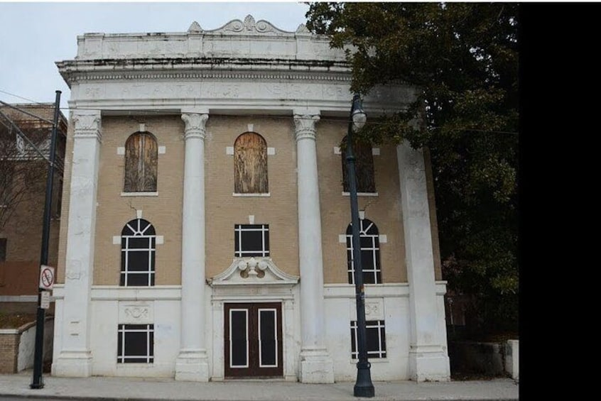 A classical building with columns, arched windows, and a central pediment. 4