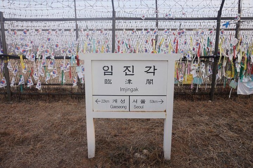 Un cartel con texto coreano y flechas indicando Gaeseong y Seúl. 5