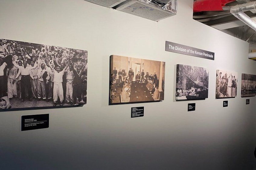 Una pared con fotografías históricas y un cartel que dice 'La división de la península coreana'. 2