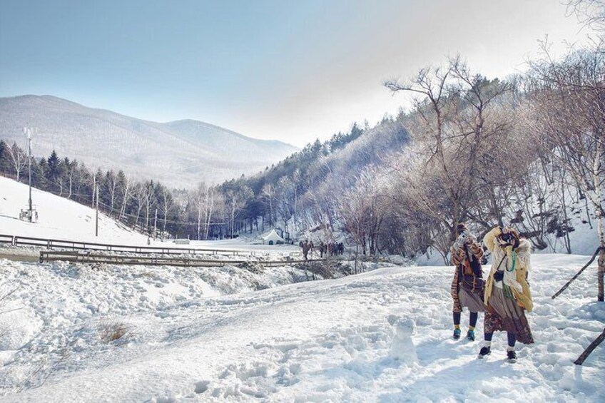 A snowy landscape with a bridge, trees, and mountains in the background. 2
