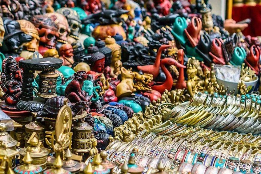 A variety of colorful statues and jewelry, including figures in traditional attire and ornate headpieces. 2