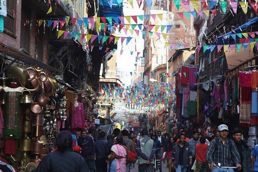 A crowded market street with colorful triangular flags. 4