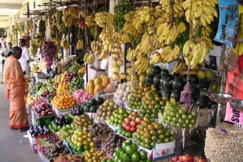 A fruit market with various fruits like bananas, apples, and oranges displayed for sale. 4