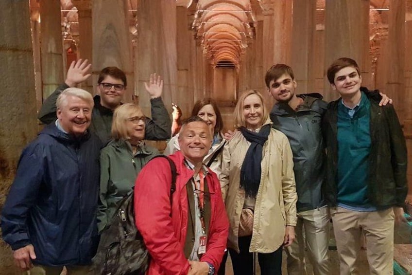 Un gruppo di persone che posa davanti a una struttura in legno con soffitti a volta. 2