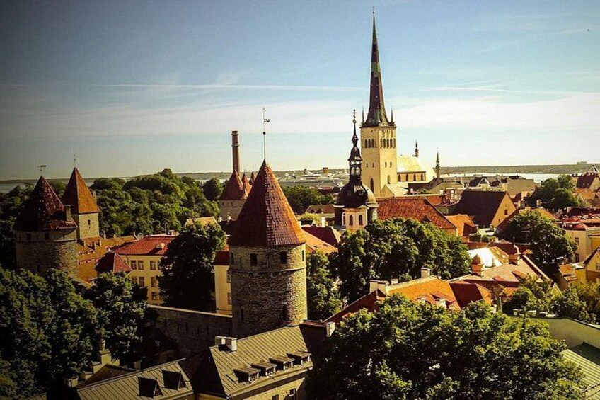 Eine Stadt mit historischen Gebäuden, einer markanten Kirche mit einem hohen Kirchturm und einer burgähnlichen Struktur mit mehreren Türmen. 3
