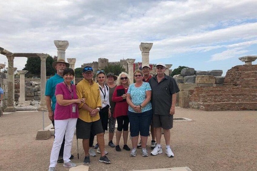 Un groupe de personnes se tient devant des ruines antiques, avec des colonnes et des structures en pierre. 5