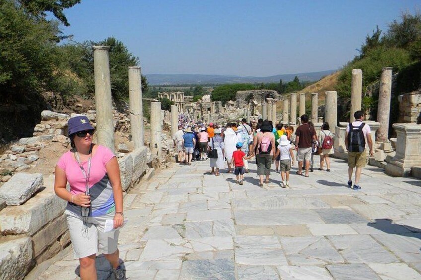 Un groupe de personnes marchant sur d’anciens escaliers en pierre, entourés de colonnes. 4