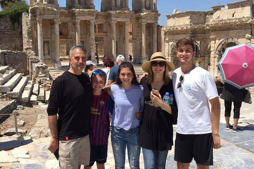 A group of people standing in front of ancient ruins with columns and steps. 2