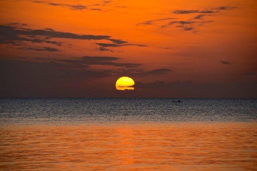 Un coucher de soleil sur l’océan, avec un bateau à l’horizon. 2