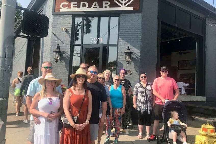 Un groupe de personnes se tient devant un bâtiment sur lequel on peut lire l’inscription « CEDAR 701 ». 2