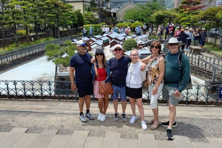 A group of people standing on a bridge with a canal and buildings in the background. 4