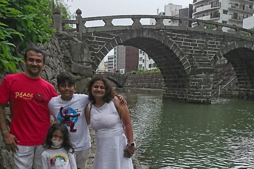 A family posing in front of a stone bridge over water with buildings in the background. 3