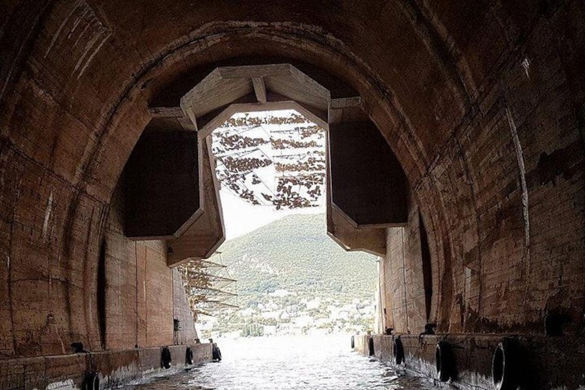 Una estructura de piedra con arco que ofrece vistas a una ladera. 3