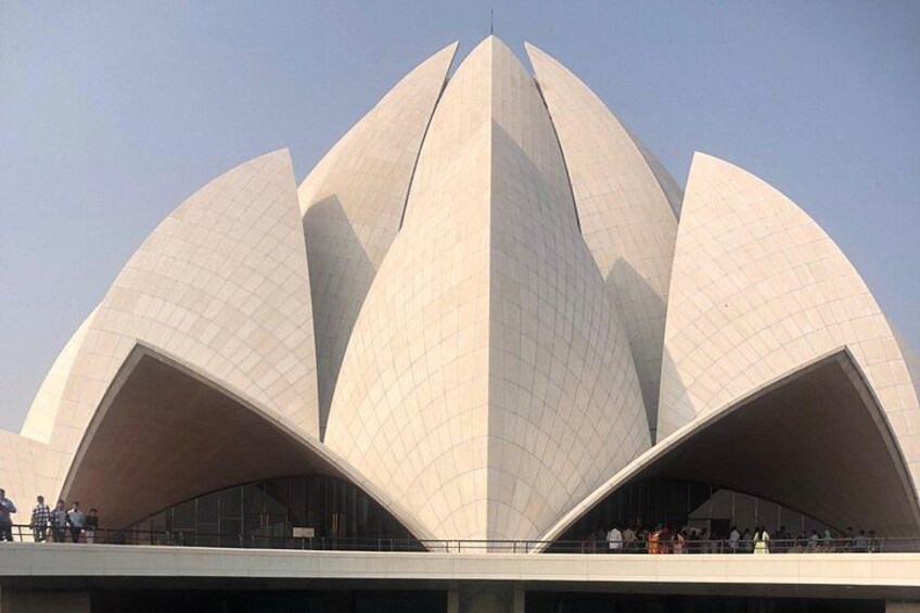 A large, white, lotus-shaped building with a grid pattern on its surface. 5