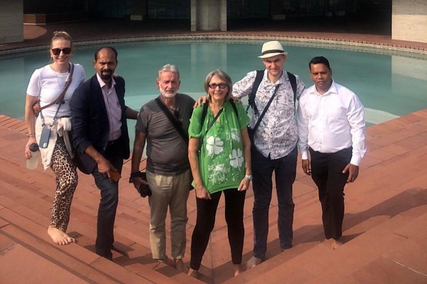 A group of people standing by a pool with a tiled walkway. 4