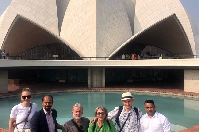 A group of people standing in front of a modern architectural structure with a large pool. 3