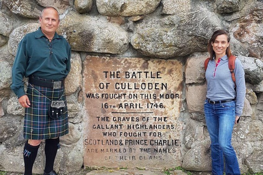 Une plaque commémorative relatant la bataille de Culloden, un homme portant un kilt et une femme se tenant à côté. 5