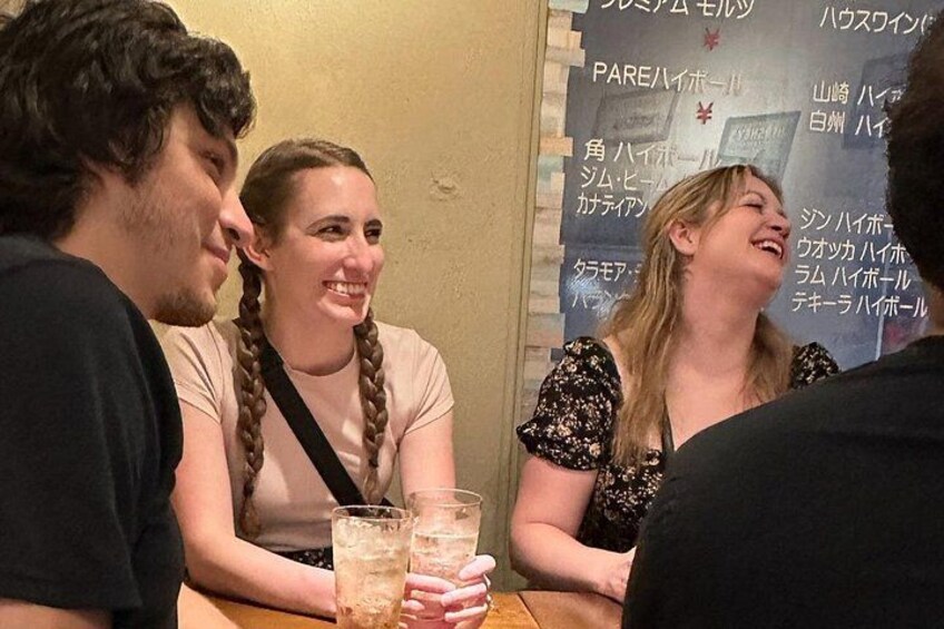 Trois personnes sont assises à une table, devant des boissons. 2