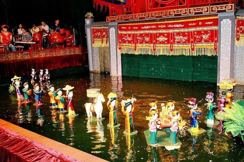 A traditional Chinese water puppet show with performers in colorful costumes. 1