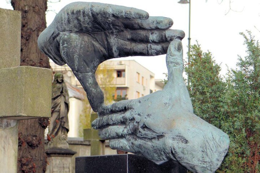 A large bronze sculpture of a hand holding a smaller hand. 1
