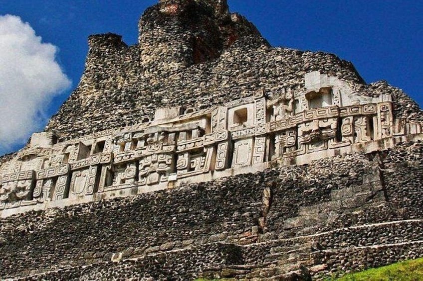 Una gran estructura de piedra antigua con intrincados grabados y una base rocosa y empinada. 1