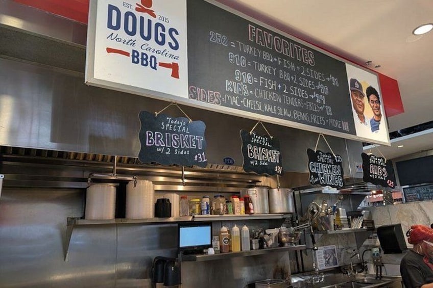 A restaurant interior with a menu board displaying BBQ favorites and specials. 3