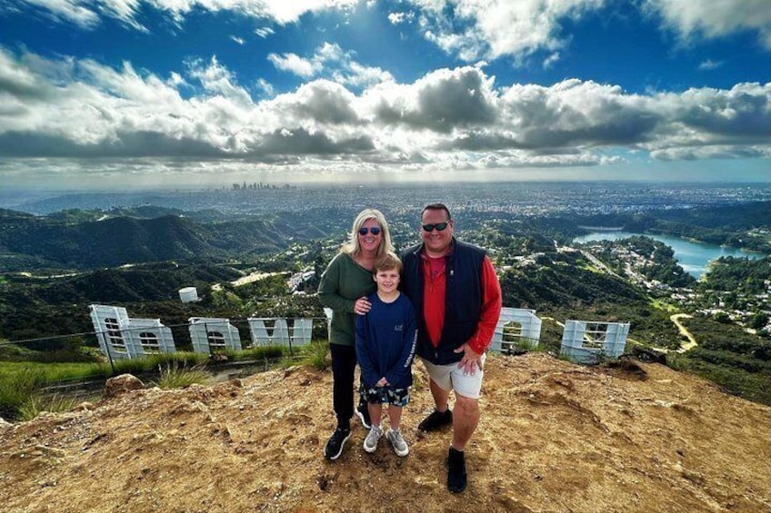 A family on a mountain with a cityscape in the background. 4