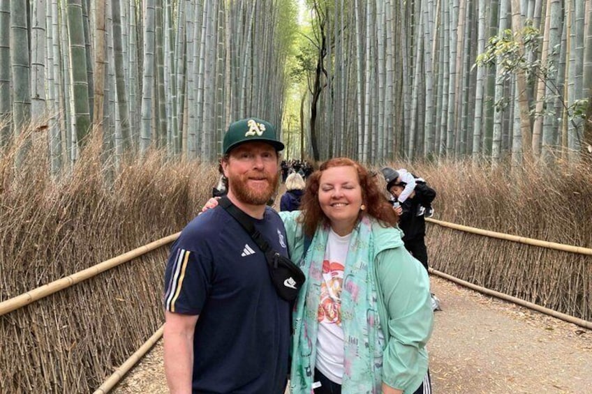 Two people standing on a bamboo forest walkway. 1