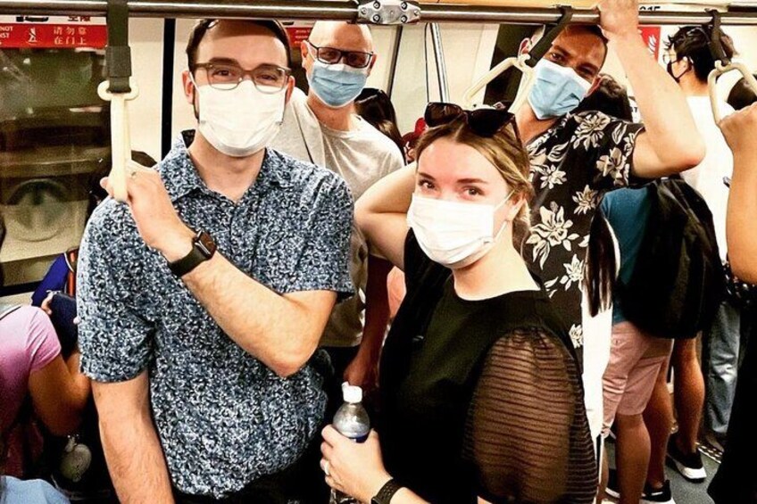 Un train de métro bondé, où les passagers portent des masques. 4