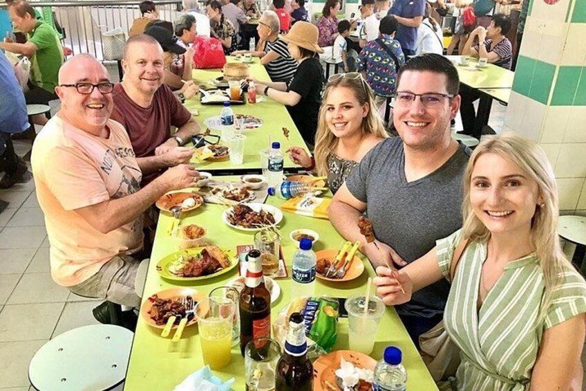 Een groep mensen zit aan een tafel met eten en drinken. 1